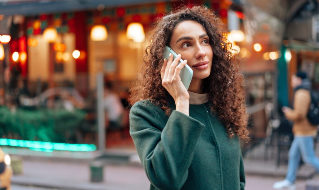 A woman makes a phone call to a business which will be logged as data through call tracking services.